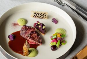 Taubensupreme aus dem Hause Mieral, Zuckererbsen, Bohnenpüree, Rote-Bete-Tatin und Lakritzjus (Copyright: Alexandra Battut - Agence Camiller Carlier)
