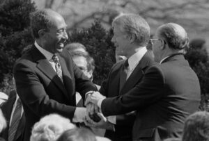 Präsident Jimmy Carter schüttelt die Hände von Ägyptens Präsident Anwar Sadat und Israels Premierminister Menachem Begin bei der Unterzeichnung des ägyptisch-israelischen Friedensvertrags auf dem Gelände des Weißen Hauses, 26. März 1979. (Copyright: Wikimedia Commons)