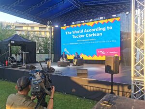 Manifestation du Mathias Corvinus Collegium en août 2023, en compagnie de Tucker Carlson, souvent décrit comme « présentateur vedette trumpiste » (Copyright : Wikimedia Commons)