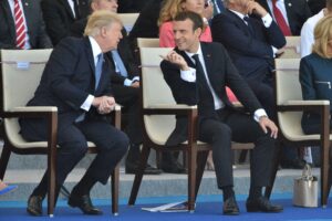 Emmanuel Macron sitzend im Gespräch mit Donald Trump