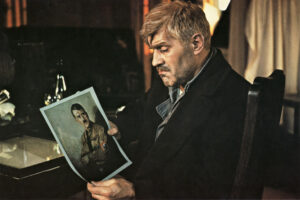 Filmausschnitt, Mann schaut ein Foto von Adolf Hitler an