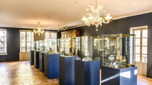 Ausstellugsraum mit vielen Vitrinen und Kronleuchter