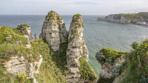 Im Vordergrund zwei lange, spitze Felsen, im Hintergund das Meer