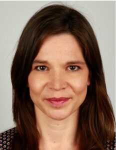 frontales Portrait von Julia Borutta, braune lange Haare und braune Augen, leichtes Lächeln