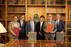 Gruppenfoto. Sechs Personen mit alten Büchern in den Händen, im Hintergrund Bücherregale
