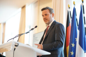 Mann mit Anzug und Krawatte am Redepult