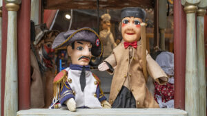 Zwei Holzpuppen, eine in altertümlicher Kleidung, die andere in der Kleidung Napoleons