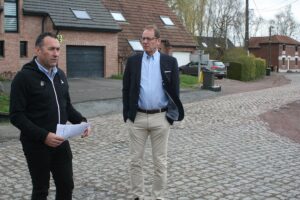 Zwei Männer auf einerKopfsteinpflasterstraße in einem Wohngebiet