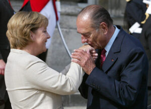 links Angela Merkel, rechts Jacques Chirac, der die Hand von Angela Merkel küsst