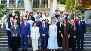 Gruppenbild, Menschen in Anzügen und Kleidern auf einer Treppe