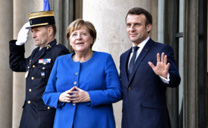 Links Angela Merkel, rechts Emmanuel Macron, der winkt