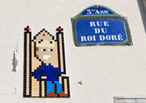 Straßenschild "Rue du roi doré", links davon ein Mosaik eines Königs auf einem Thron