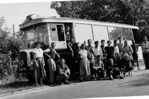 schwarz-weißes Foto, eine Gruppe Menschen vor einem Bus