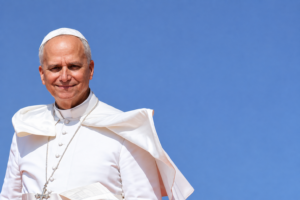 Papst Leo in weißem Gewand vor einem blauen Himmel